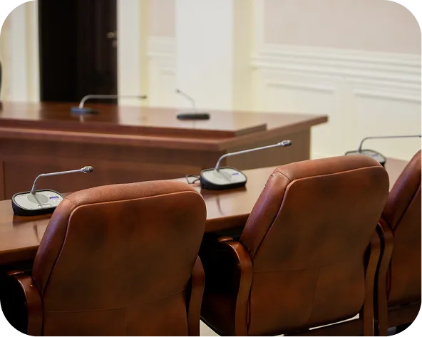 Council chamber with brown leather chairs, timber desks and microphones